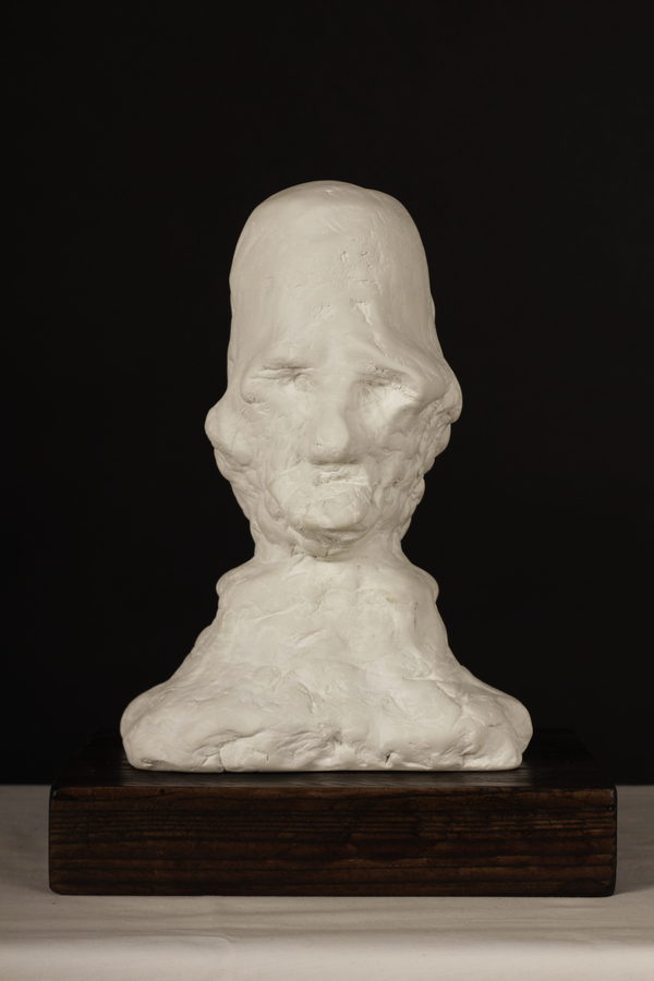 Head of an Old Man (2023) by Valeriu Cazacevschi. A pale bust of an old man with a tall, rounded head, on a dark wooden base.