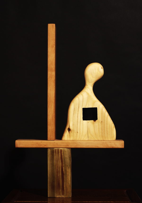 The Window of My Soul (Geometrical Structure) (2023) by Valeriu Cazacevschi. A pale carved wooden figure with a square opening, set against an upright post and a horizontal beam.