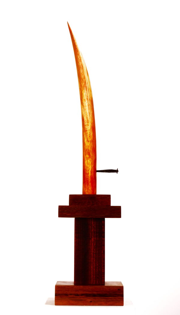 Wind (2023) by Valeriu Cazacevschi. A thin curved blade of reddish wood rising from a dark wooden stand.