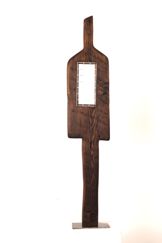 Dark upright wooden sculpture with a narrow rectangular opening