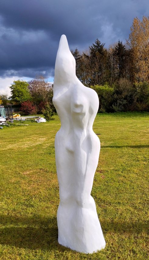 Opposite view of the white standing sculpture outdoors
